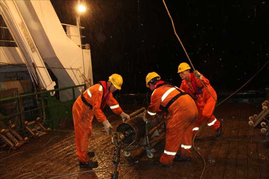 “海洋六號”科考隊員太平洋雨夜中作業(yè)收樣品